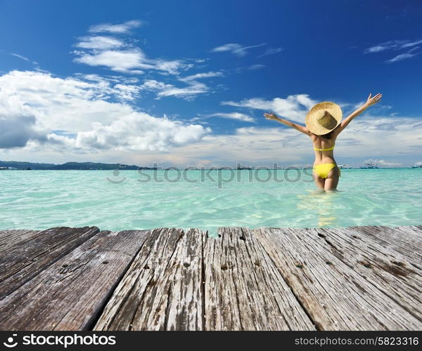 Girl on a tropical beach with outstretched arms