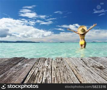 Girl on a tropical beach with outstretched arms