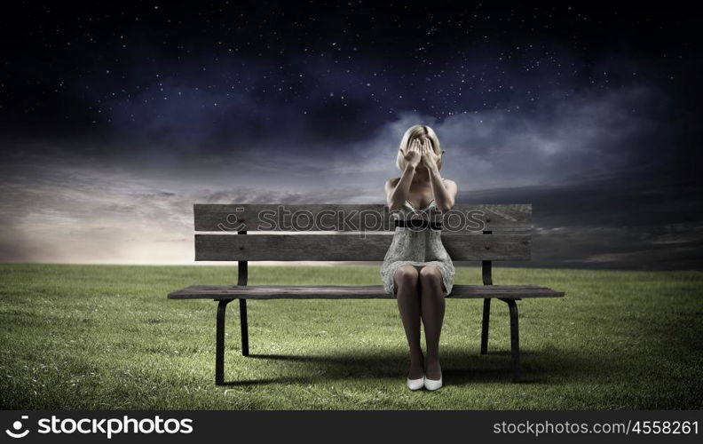 Girl on bench. Young woman sitting on bench closing eyes with palms