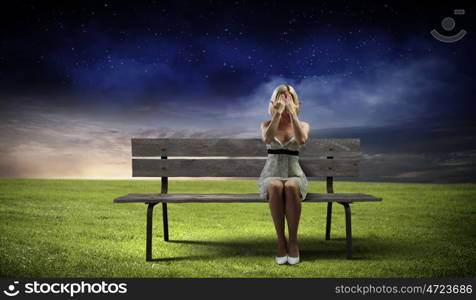 Girl on bench. Young woman sitting on bench closing eyes with palms