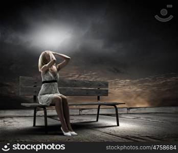 Girl on bench. Young woman sitting on bench closing eyes with palms