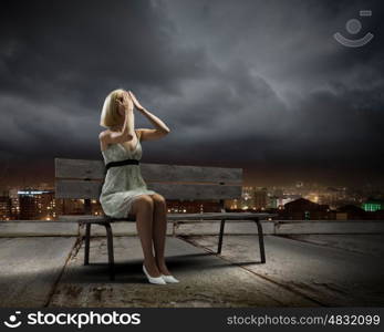 Girl on bench. Young woman sitting on bench closing eyes with palms