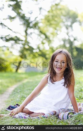 girl on blanket smiling at viewer
