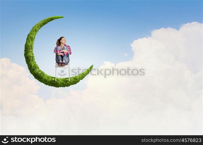 Girl on moon. Young pretty girl sitting on moon in sky