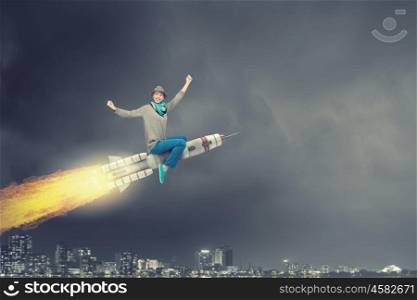 Girl on rocket. Young cheerful girl riding on rocket high in sky