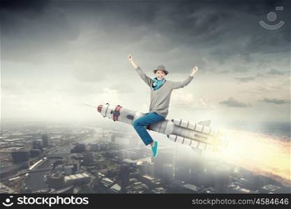 Girl on rocket. Young cheerful girl riding on rocket high in sky