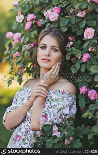 Girl on the background of a Bush with lilac flowers.. A large portrait of a beautiful girl in a light dress 1640.