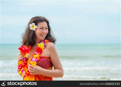 Girl on the background of the sea in pareo and traditional Hawaiian Lei