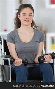 girl on the wheelchair holding weights