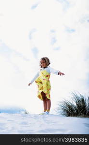 Girl on top of a sand dune