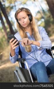 girl on wheelchair listening to music in nature