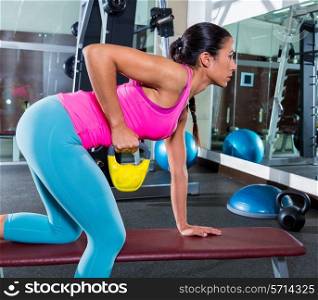 girl one arm kettlebell bent over row on bench workout exercise at gym