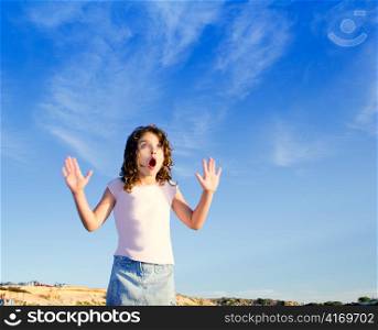 Girl open arms outdoor under blue sky with surprise gesture