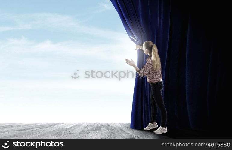 Girl opening curtain. Young woman in casual opening drape curtain