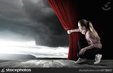 Girl opening curtain. Young woman in casual opening drape curtain
