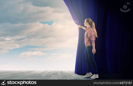 Girl opening curtain. Young woman in casual opening drape curtain