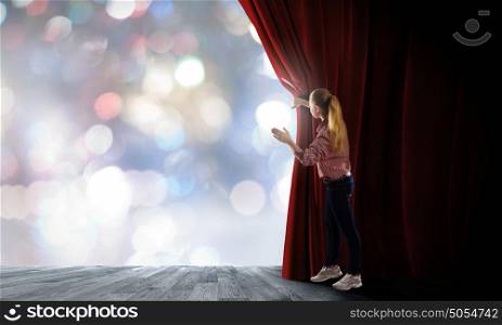 Girl opening curtain. Young woman in casual opening stage curtain