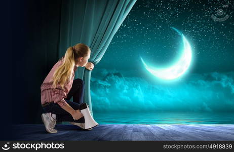 Girl opening curtain. Young woman in casual with megaphone opening curtain