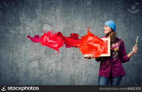 Girl painter. Young woman painter holding frame with colorful splashes