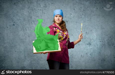 Girl painter. Young woman painter holding frame with colorful splashes