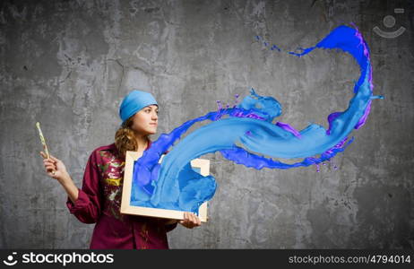 Girl painter. Young woman painter holding frame with colorful splashes