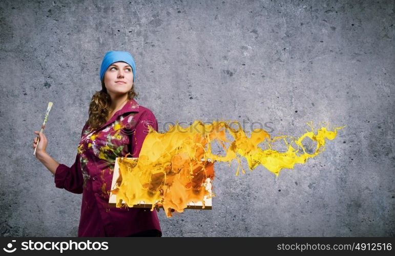 Girl painter. Young woman painter holding frame with colorful splashes