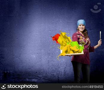 Girl painter. Young woman painter holding frame with colorful splashes