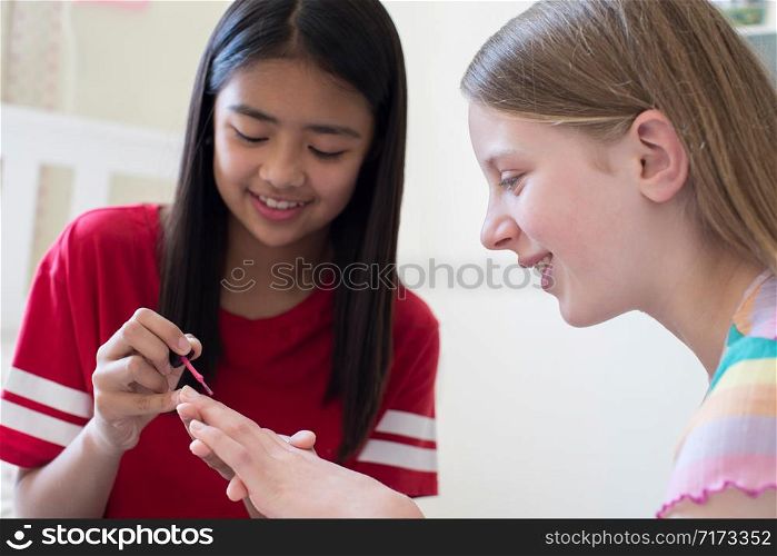 Girl Painting Friends Fingernails In Bedroom