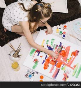 girl painting with bright gouache paper floor