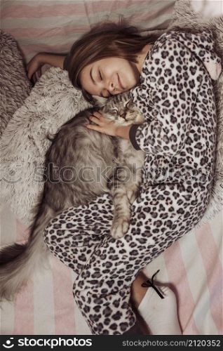 girl pajamas hugging her cat laying bed