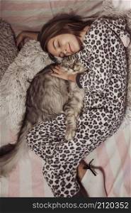 girl pajamas hugging her cat laying bed