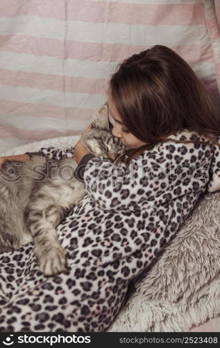 girl pajamas kissing her cat