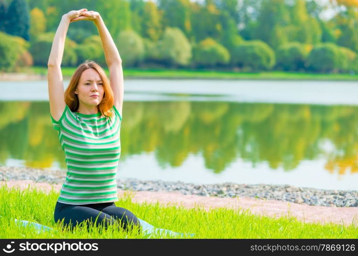 girl performs stretching exercises back muscles in nature