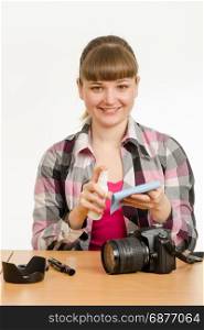 Girl photographer performs cleaning of the camera body from external contamination