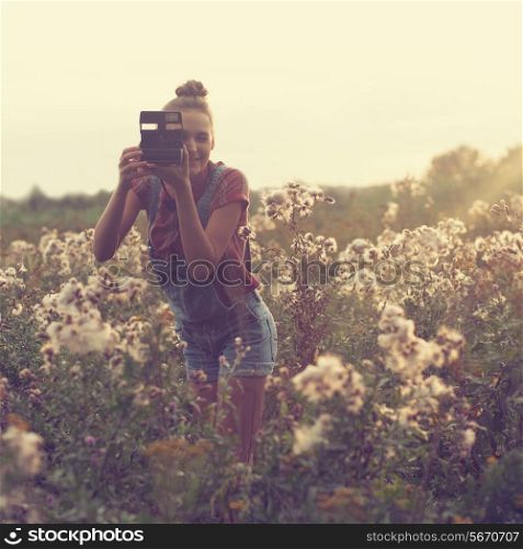 Girl photographer taking photo in the field