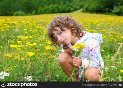Girl picking flowers in yellow spring meadow beautiful scenic in Pyrenees spain