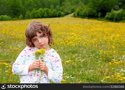 Girl picking flowers in yellow spring meadow beautiful scenic in Pyrenees spain