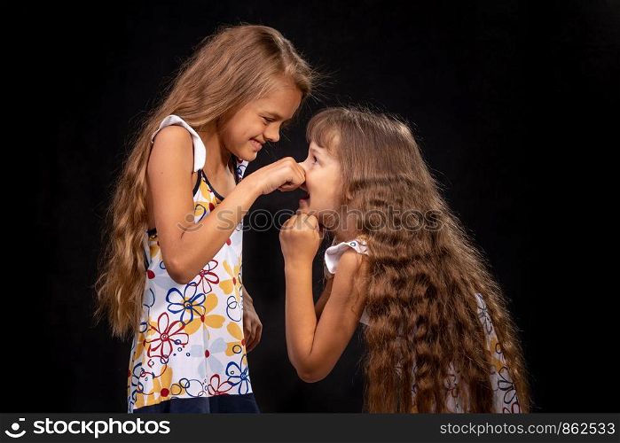 Girl pinched a hand on the nose of another girl