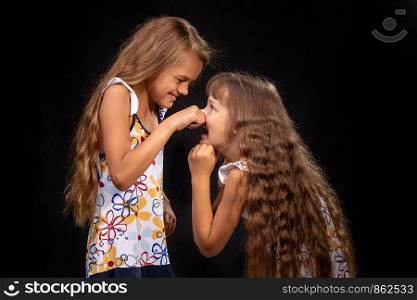 Girl pinched a hand on the nose of another girl