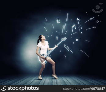 Girl play guitar. Young pretty girl in shorts and shirt playing imaginary guitar