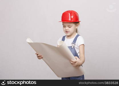 Girl playing Builder launched the drawing up and looks into the drawing