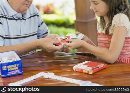 Girl playing cards with her grandfather