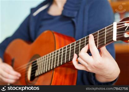 girl playing classical acoustic guitar close up