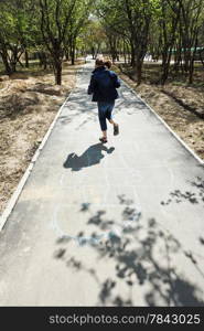 girl playing in hopscotch in urban garden in spring