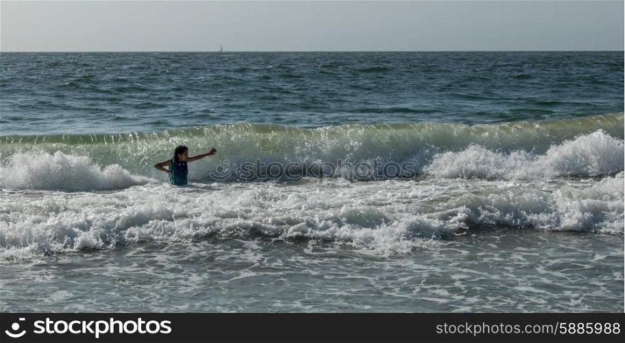 Girl playing in ocean waves, Vina Del Mar, Chile