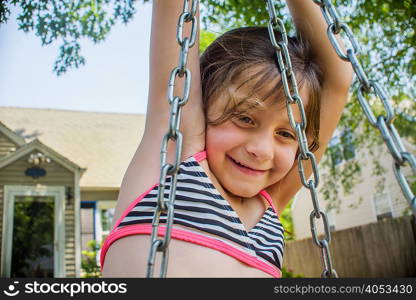 Girl playing on swing in garden