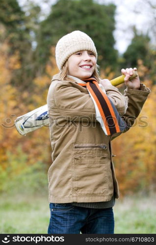 Girl playing with a cricket bat and smiling