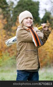 Girl playing with a cricket bat and smiling