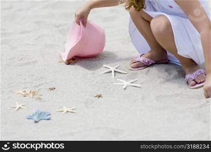 Girl playing with a starfish on the beach