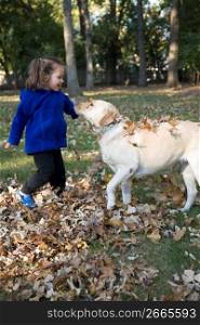 Girl playing with dog in leaves